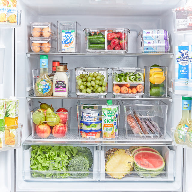 Fridge shelves organised with clear storage tubs of fruit and vegetables